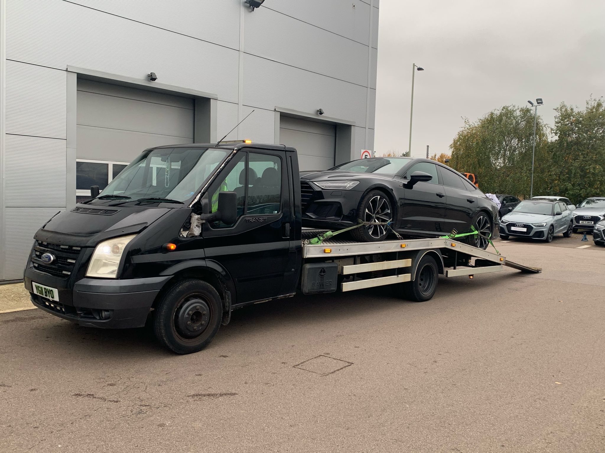 Vehicle recovery specialist helping a car stuck in a parking area.