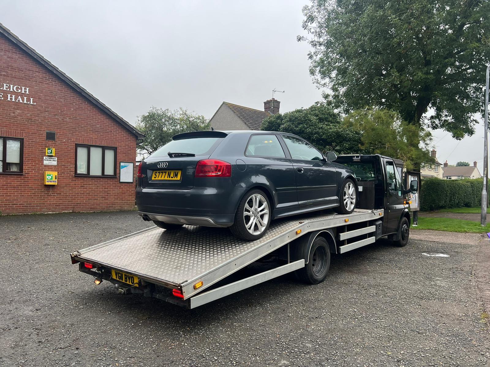 Roadside recovery truck lifting a damaged car for transport